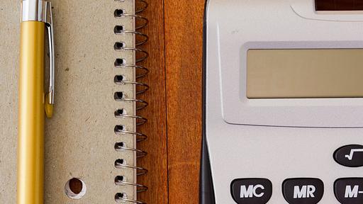 Photo of a notebook, mechanical pencil, and calculator.