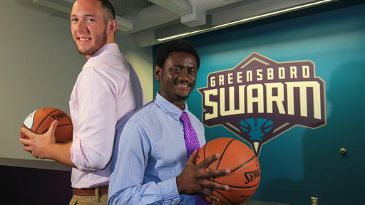Two students pose for a photo while interning for the Greensboro Swarm basketball team.