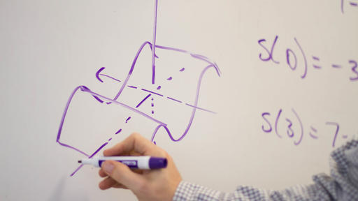 Mathematics Professor Ben Marlin works out a math problem on a whiteboard.