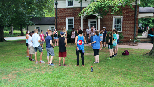 Students stand in a circle outside of the Friends Center on campus.