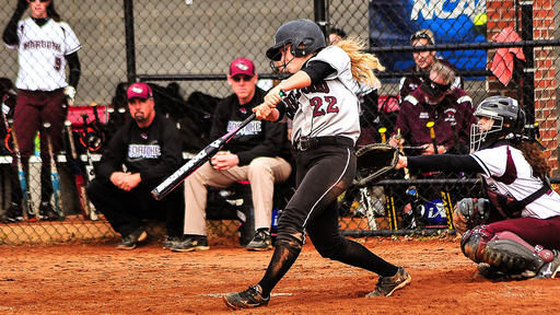 A women's softball player hits the ball with a bat.