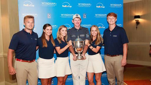 Guilford College student Shannon Petsch interned at the Wyndham Championship PGA Golf Tournament. She stands here, holding the trophy with the tournament champion, Brandt Snedeker.