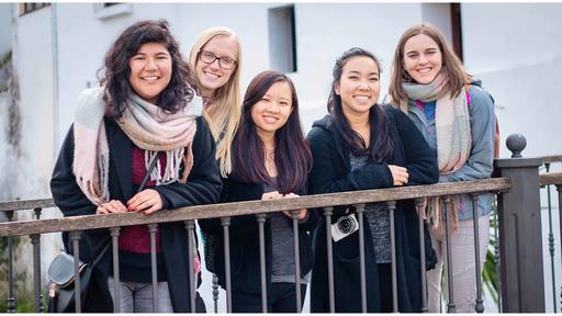 Student Gillian Sherman stands with friends behind a fence in Seville, Spain.