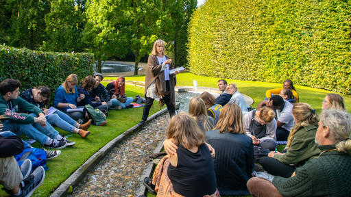 Students listen to Professor Michele Malotky outside Alnwick Castle during a study abroad trip.