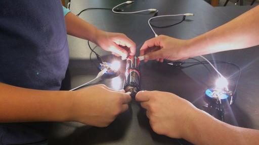 Physics students perform a lighting experiment.